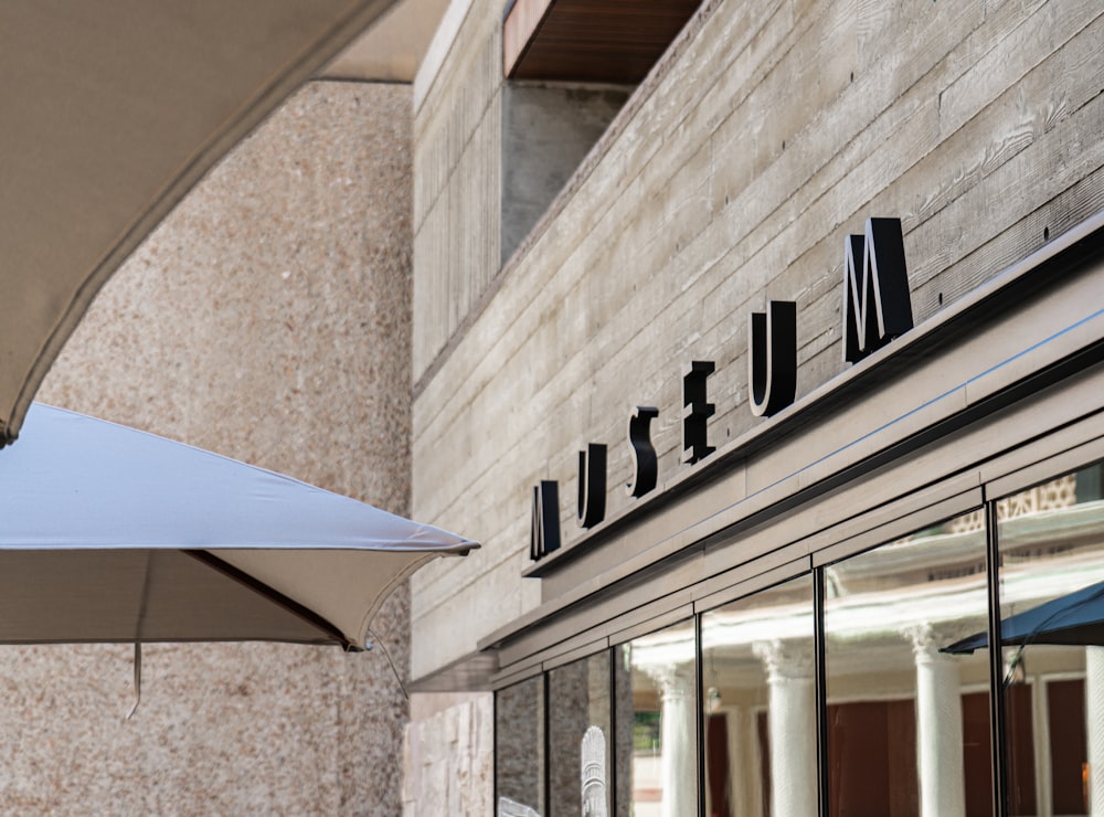 an umbrella is outside of a building with a sign on it