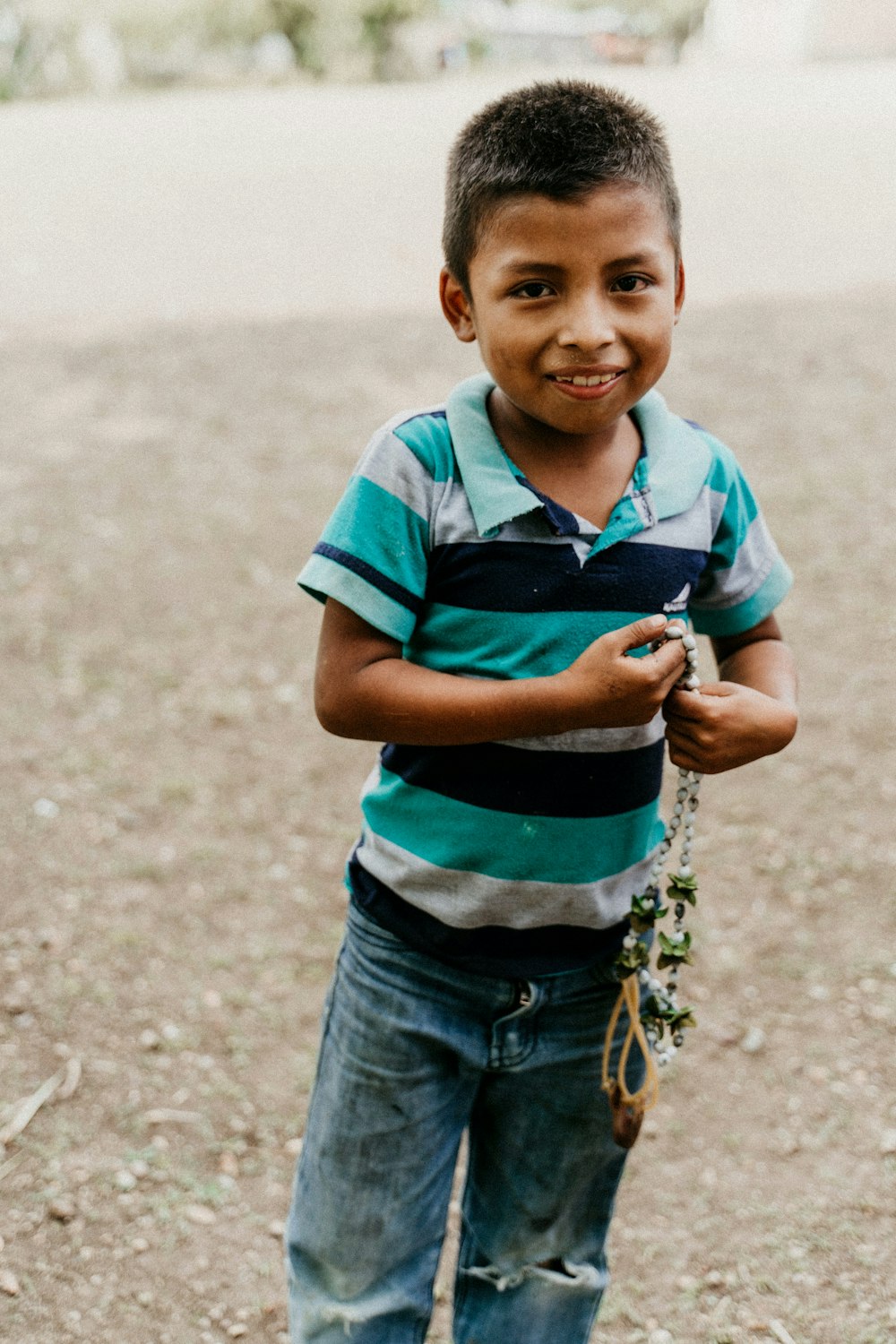 boy in blue and white stripe polo shirt and blue denim jeans