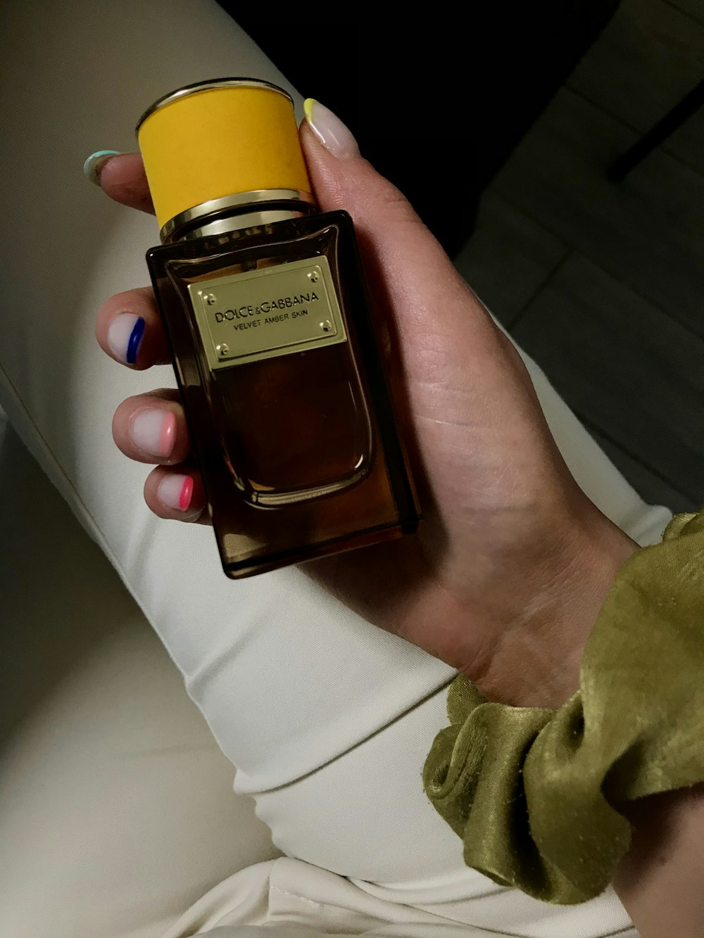 person holding black and gold perfume bottle