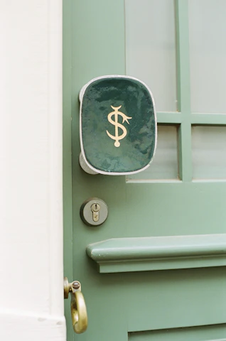 Close-up of a 'VENDIDA' sign hanging on a front door with a golden key in hand.