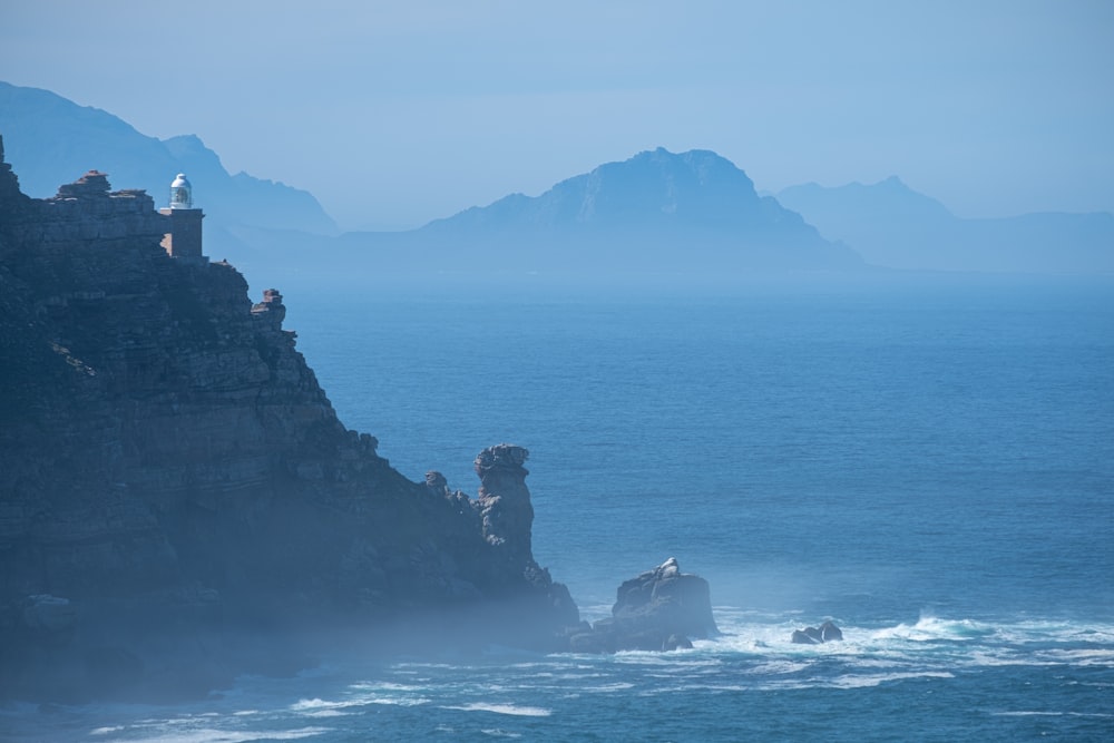 black rock formation on sea during daytime