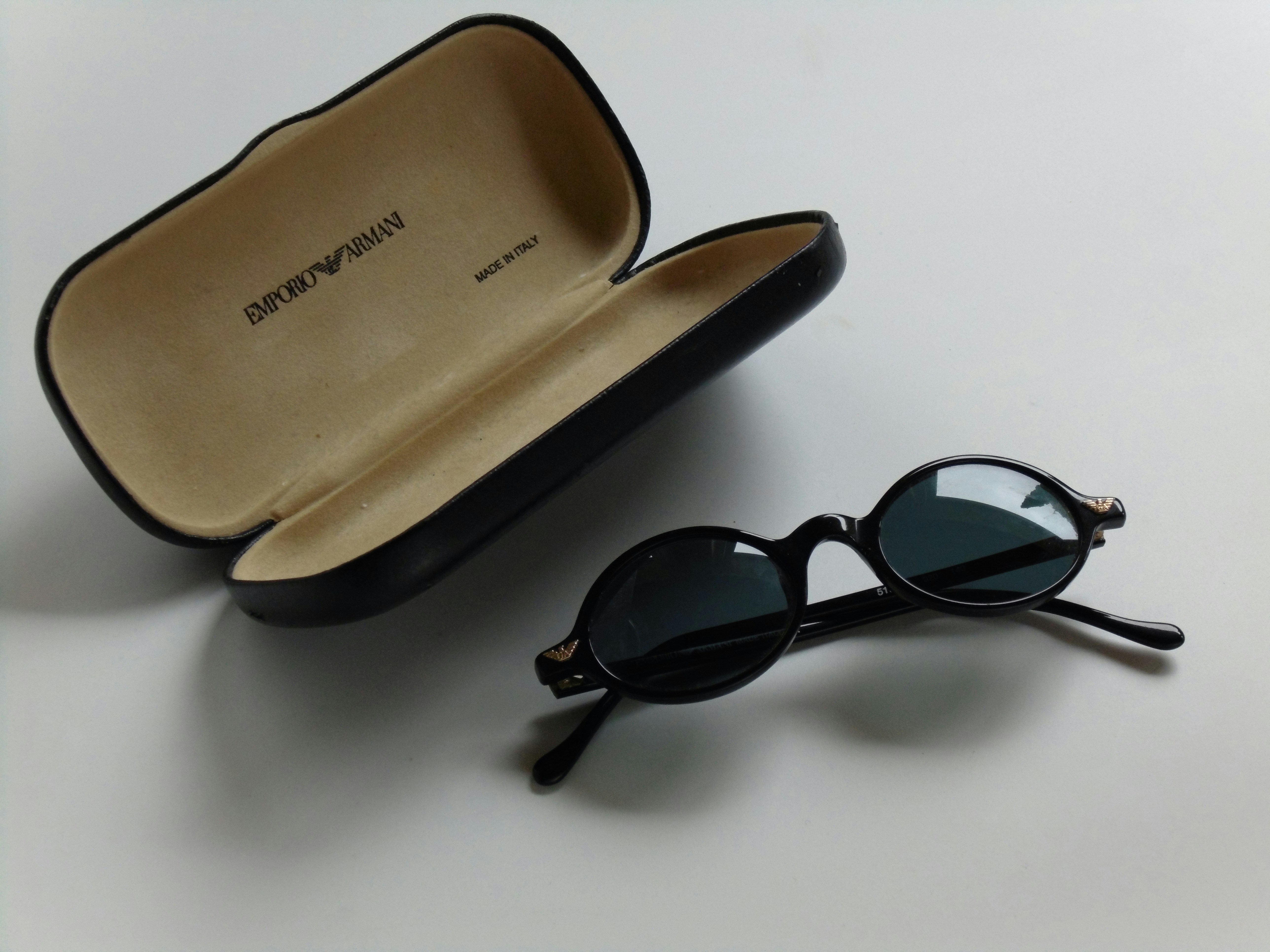 black framed sunglasses on white table