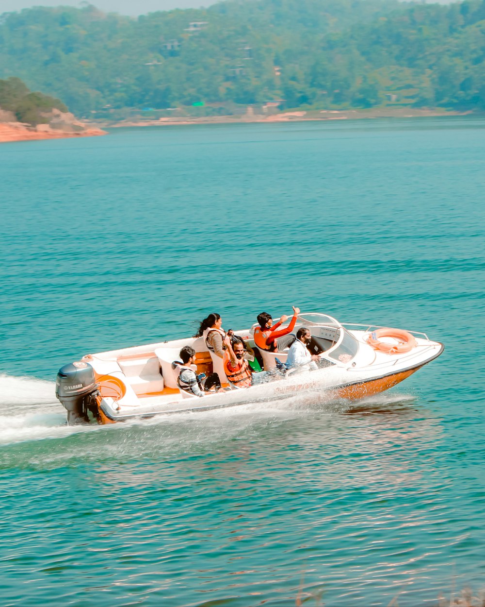 2 people riding on white and red inflatable boat on blue sea during daytime