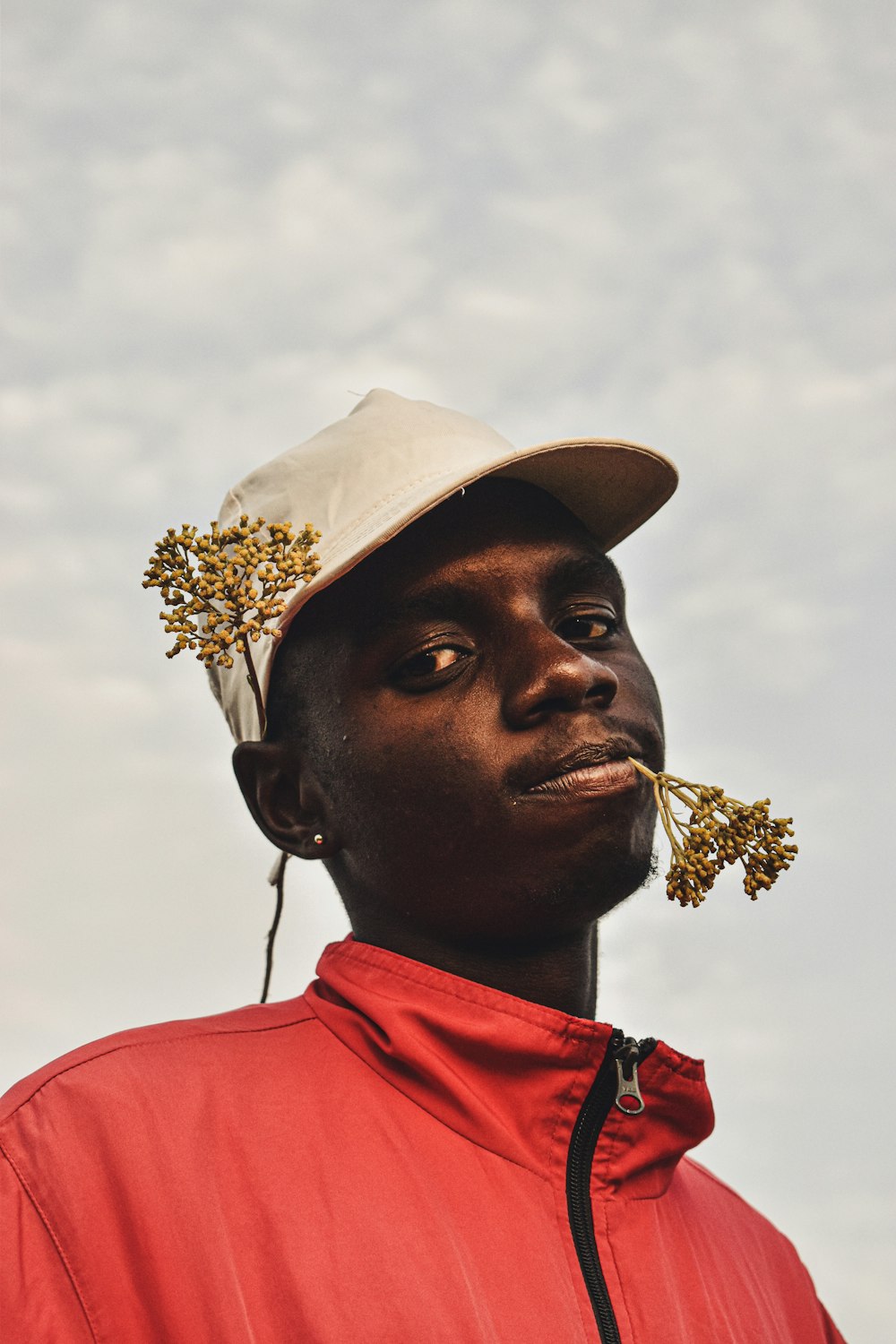 man in red polo shirt wearing white hat