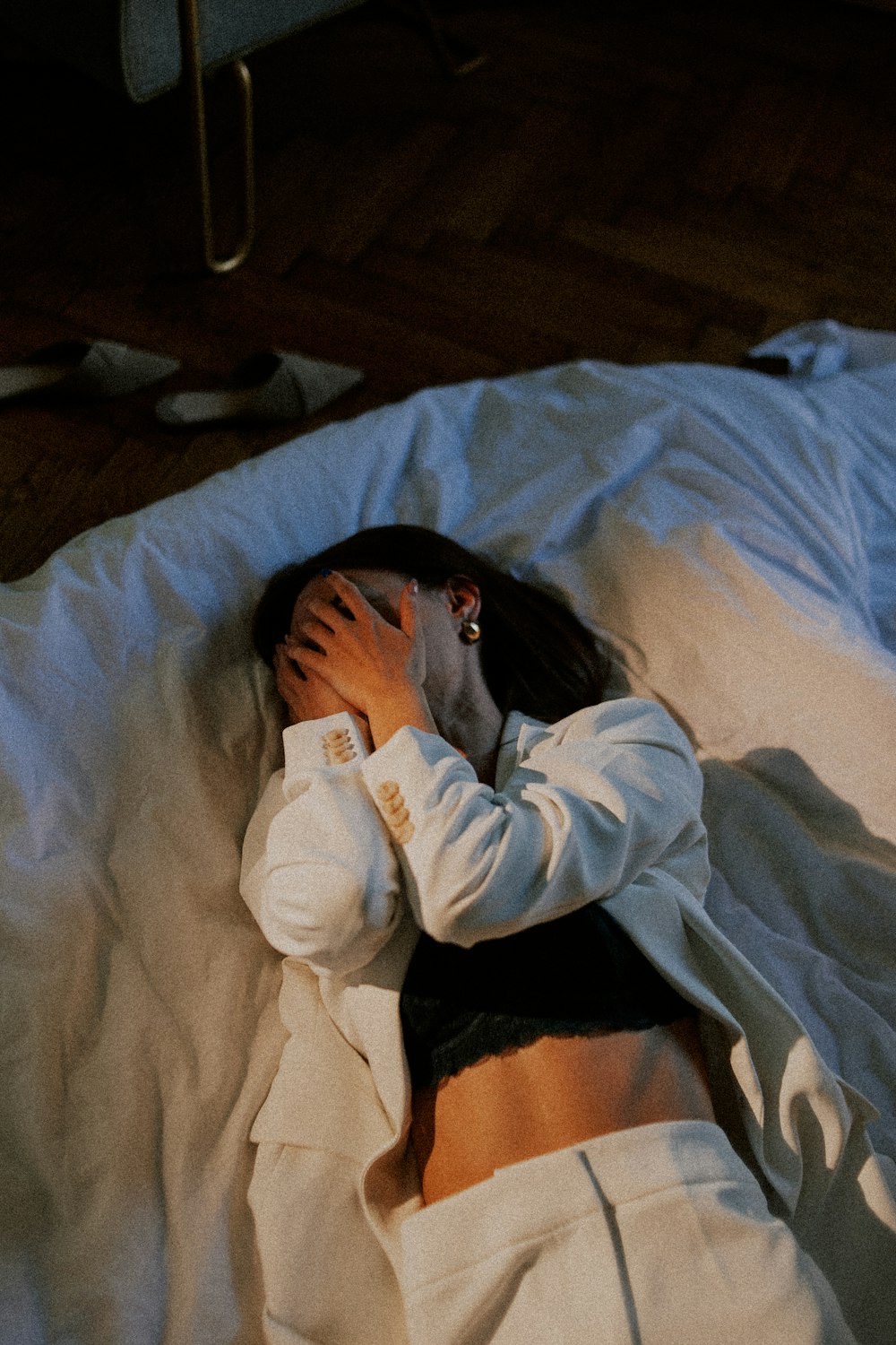 woman in white long sleeve shirt lying on bed