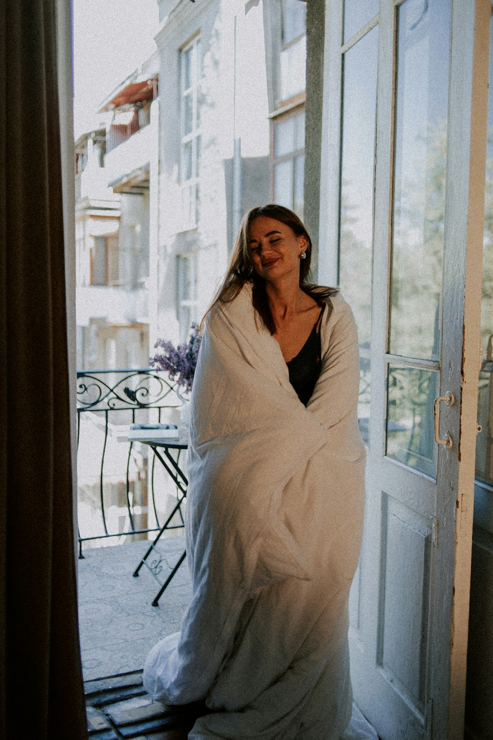 woman in white long sleeve dress standing beside glass window