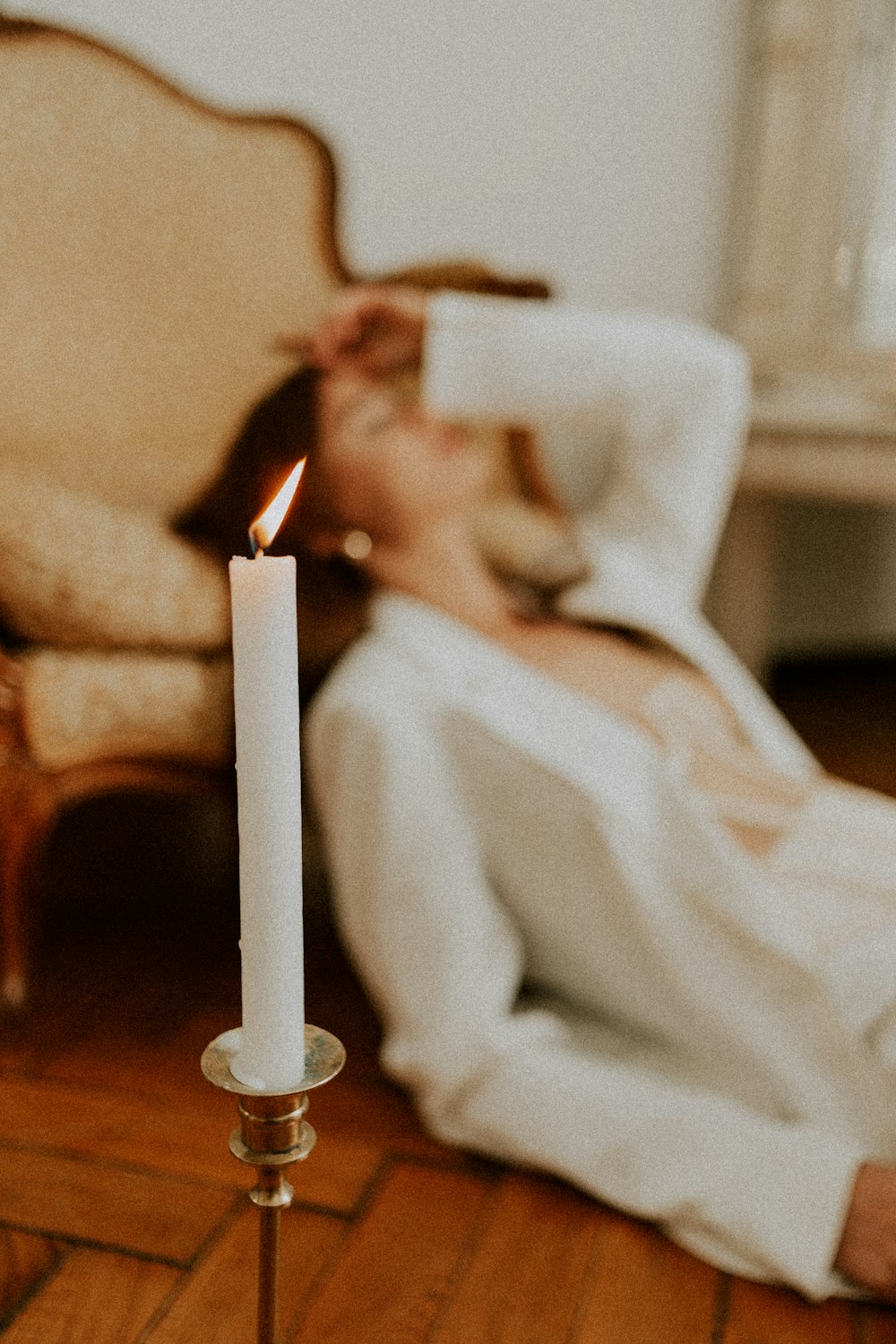 donna in abito bianco che tiene la candela bianca