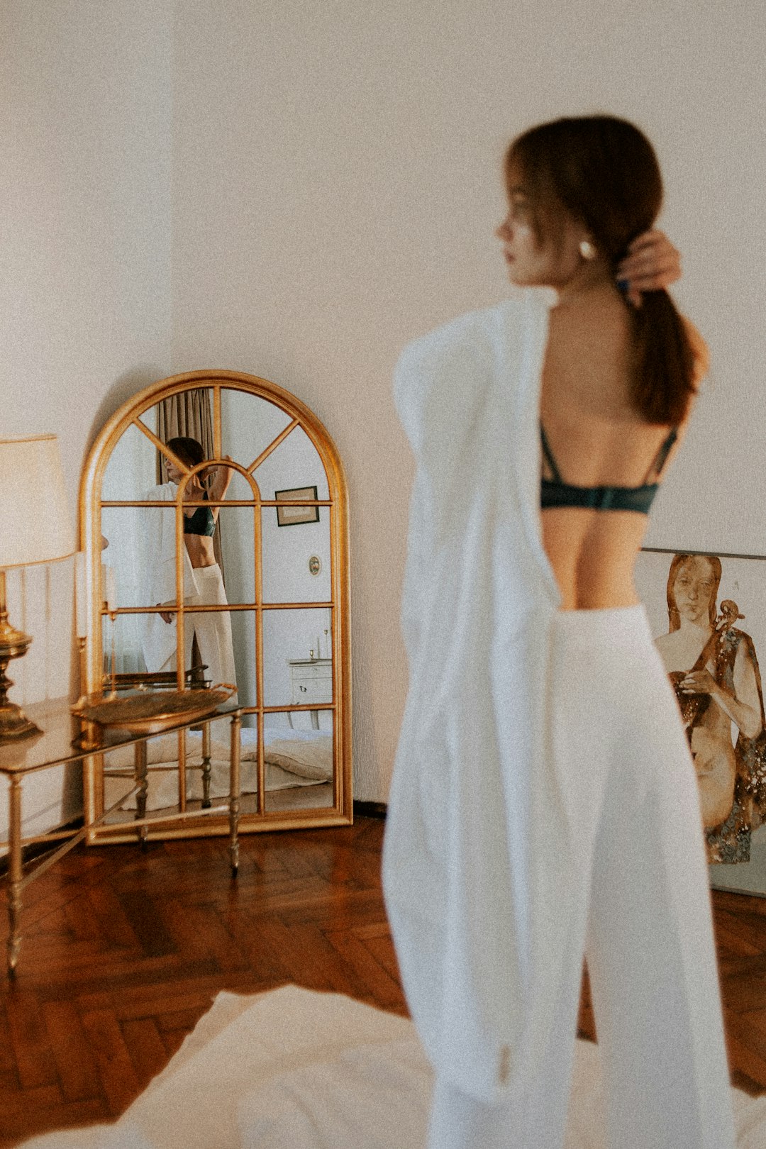 woman in white long sleeve shirt and black panty standing near brown wooden table