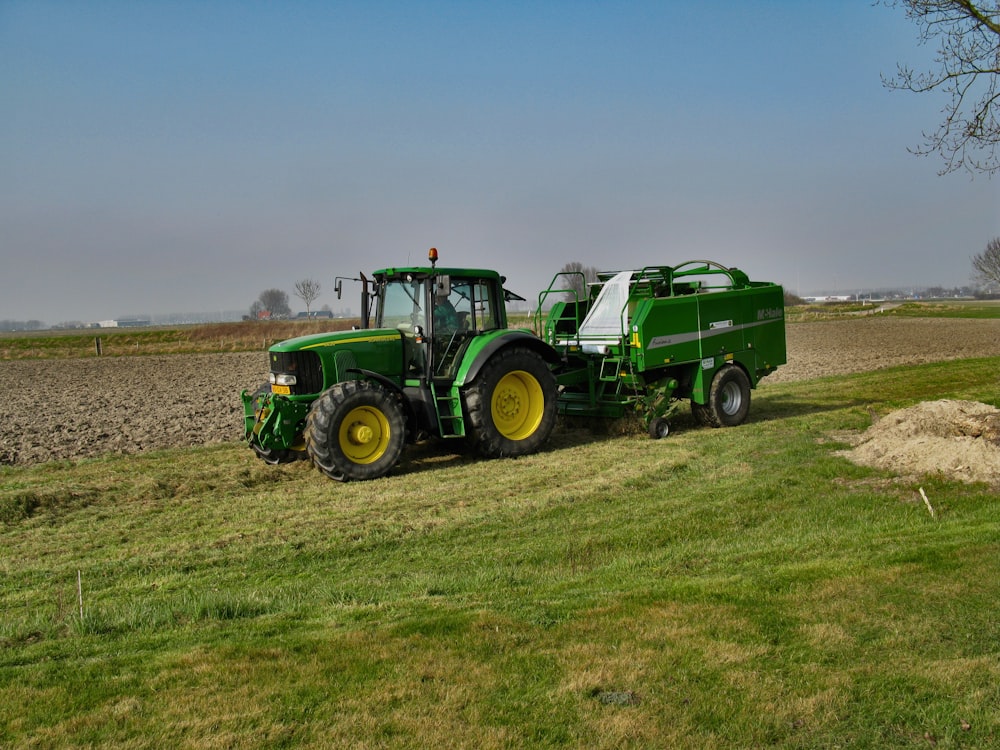Grüner Traktor tagsüber auf grünem Rasenfeld unter weißem Himmel