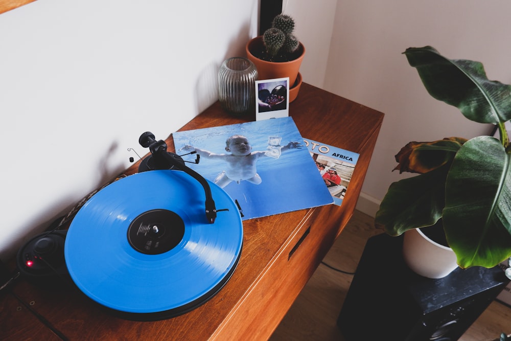 갈색 나무 테이블에 파란색 비닐 레코드