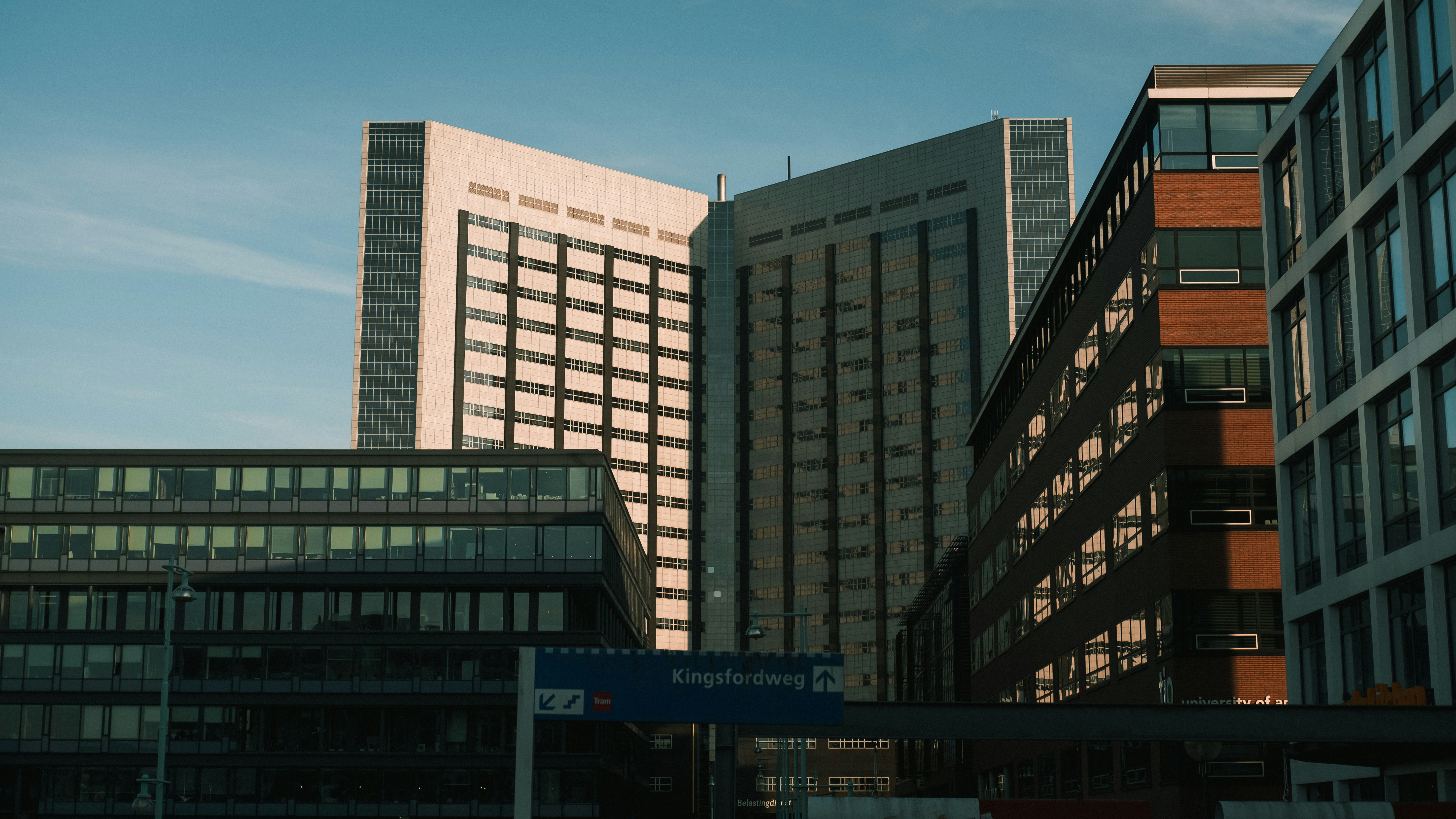 white concrete building during daytime, Metro-, tram- and train station Amsterdam Sloterdijk with some nice light on a cold and sunny winter day. 