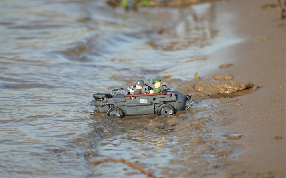 grey and black truck toy on water