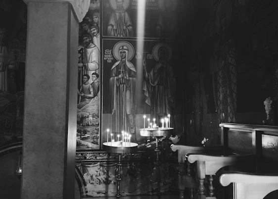 A cozy corner with traditional Eastern Orthodox icons, handmade textiles, and a softly lit candle.