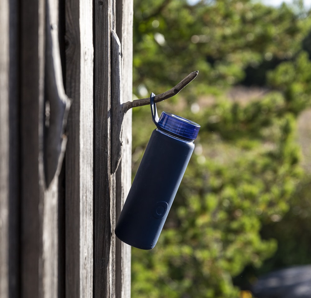 Vaso de plástico azul en ventana de madera gris