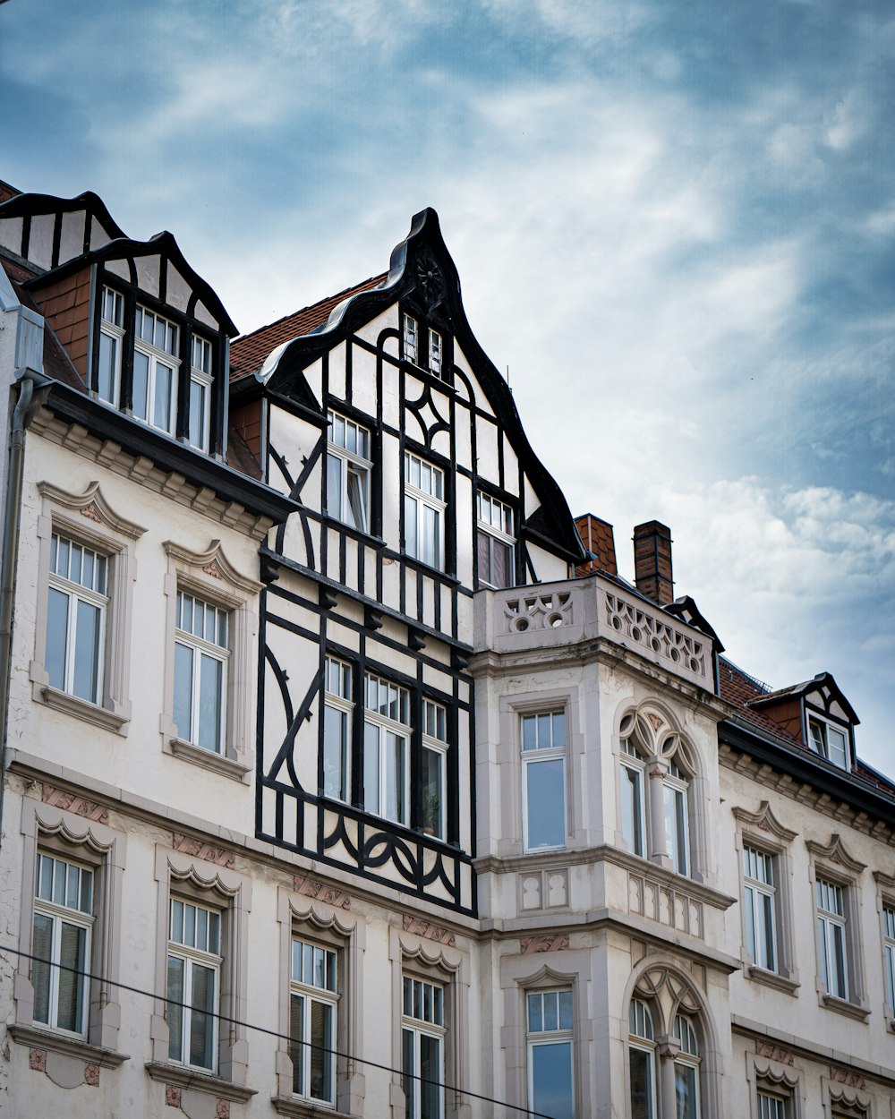 Bâtiment en béton brun sous un ciel nuageux pendant la journée