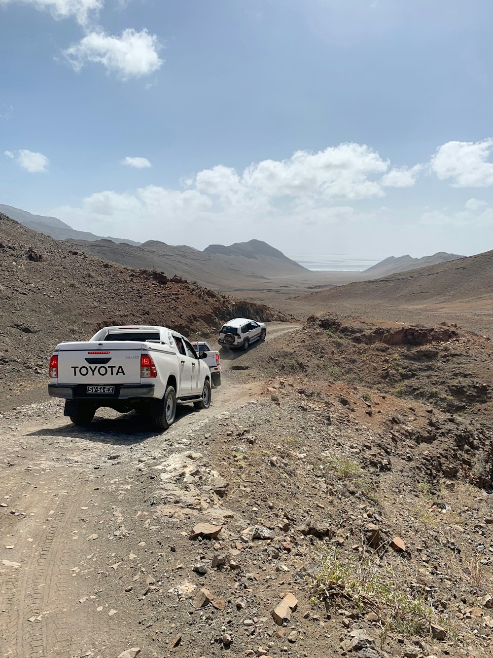 white suv on brown dirt road during daytime