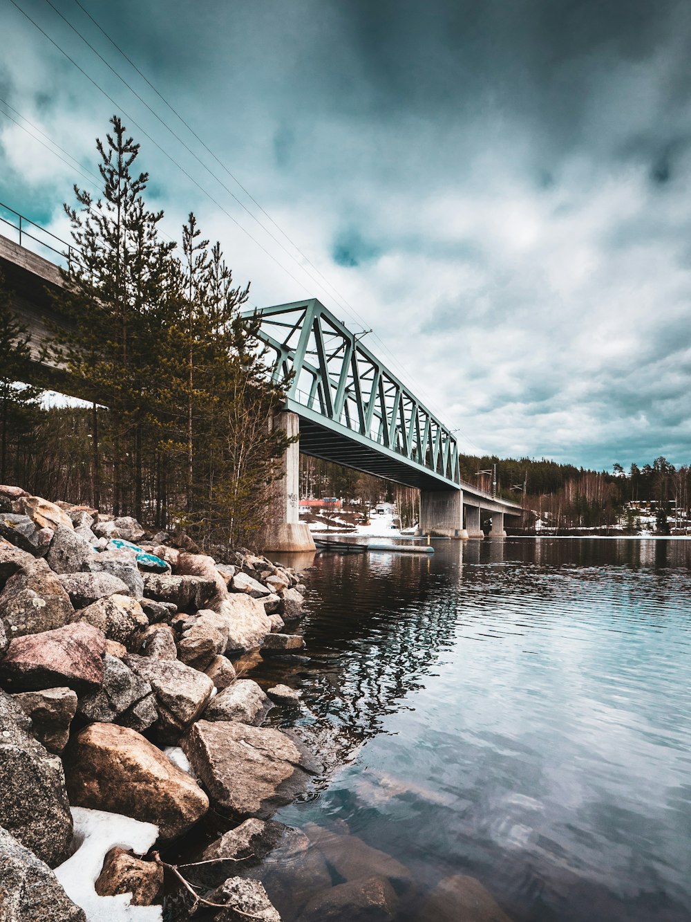 brown wooden bridge over river under cloudy sky during daytime