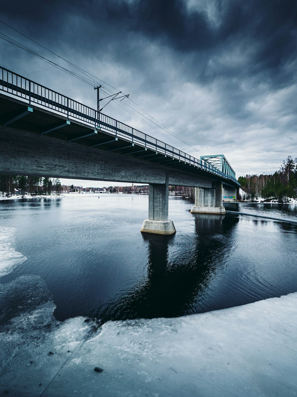 white and brown bridge over river under cloudy sky during daytime