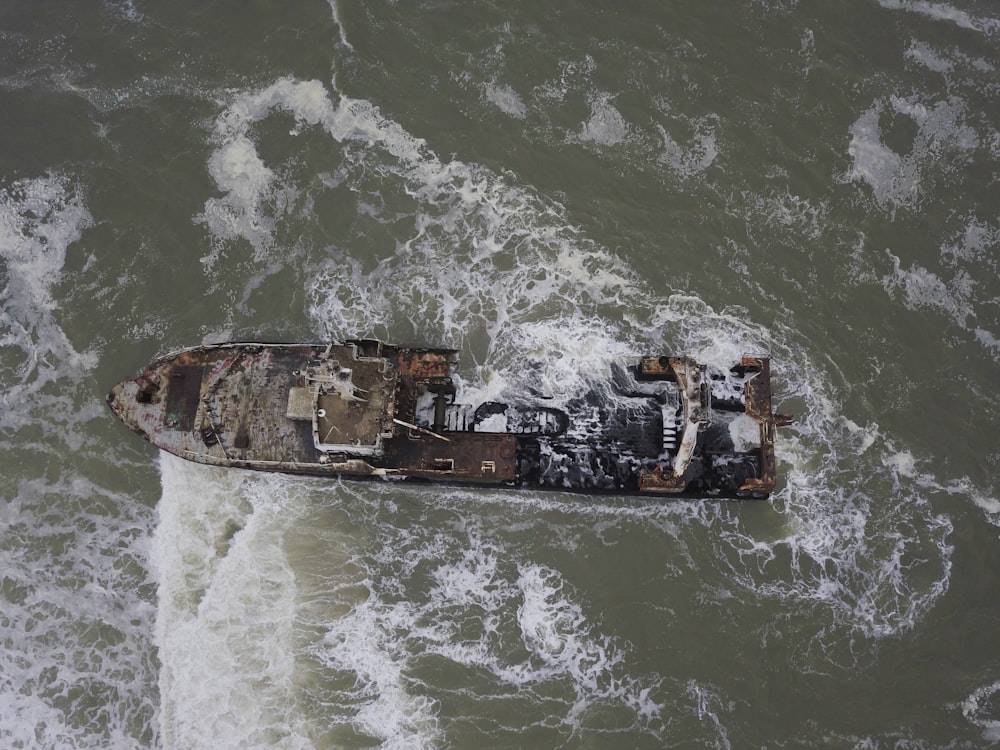 Mann im schwarzen Hemd fährt tagsüber auf einem schwarzen Boot auf dem Wasser