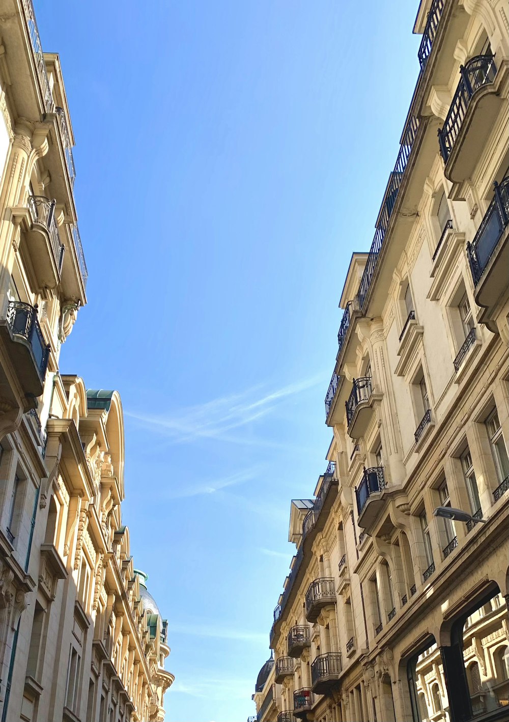 Photographie en contre-plongée d’un bâtiment en béton beige sous un ciel bleu pendant la journée