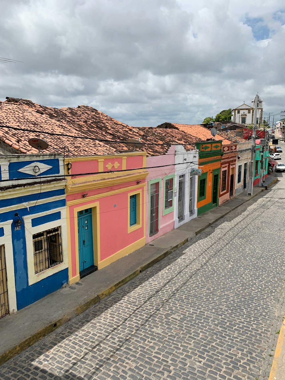 blue yellow and red concrete houses under white clouds during daytime