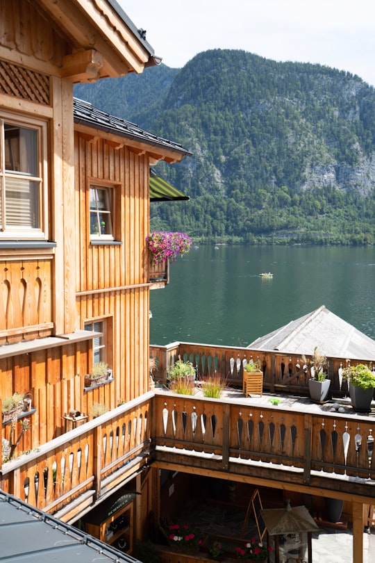 brown wooden house near lake during daytime in Hallstatt Austria Austria
