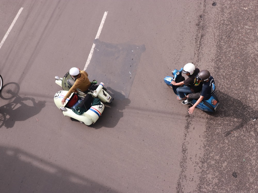 2 men riding on white and green sports bike