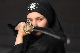 woman in black hijab holding gold ring
