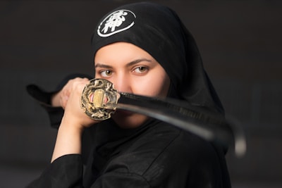 woman in black hijab holding gold ring