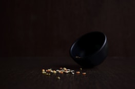 Roasted makhana and soya crisps in a minimalist black bowl with gold trim, styled on a dark background.