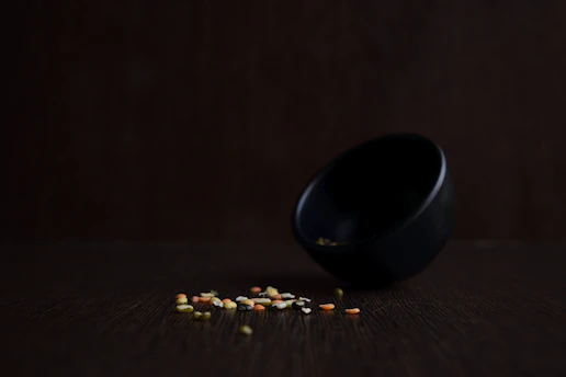 A vibrant bowl of fresh, colorful vegetables and grains, styled in a minimalist black and white kitchen setting.