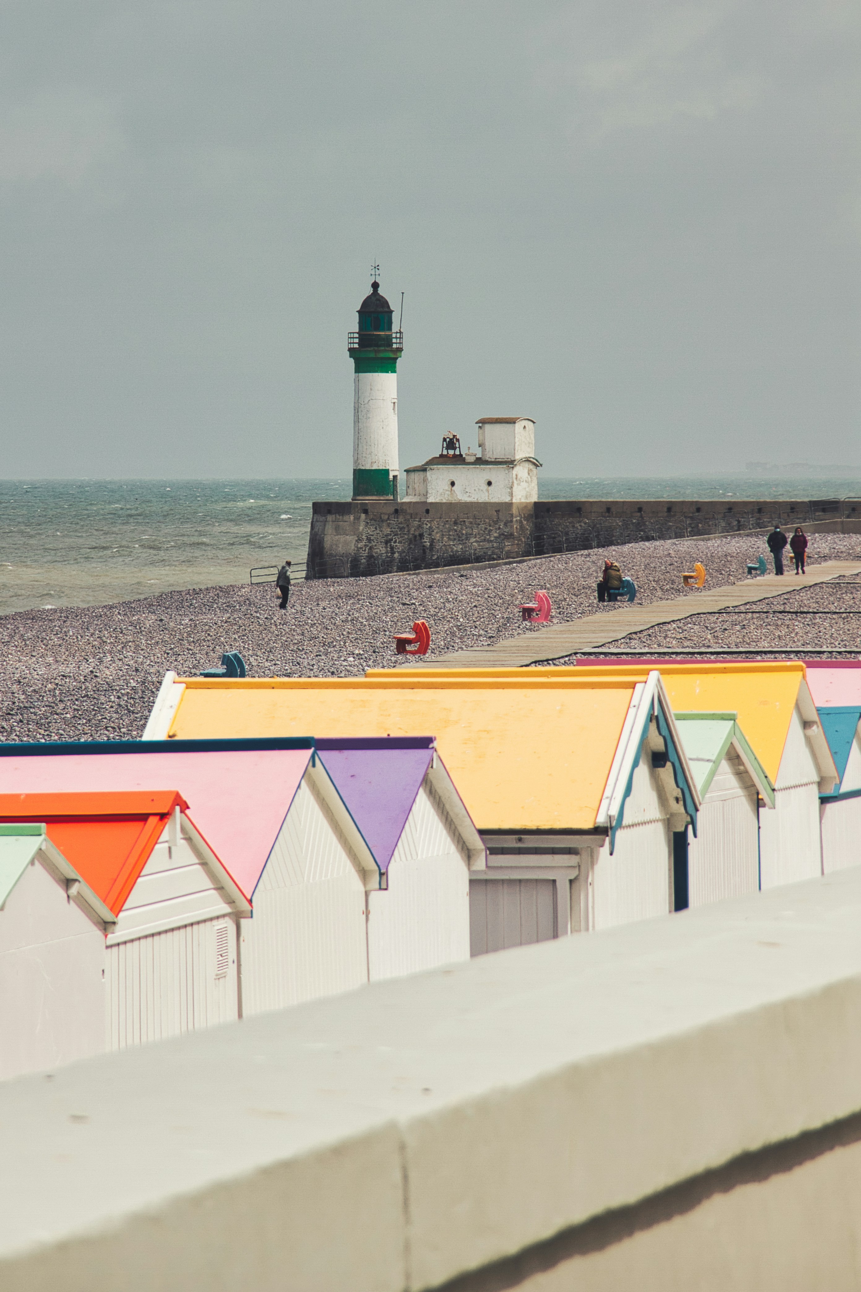 Faro blanco y rojo cerca del cuerpo de agua durante el día