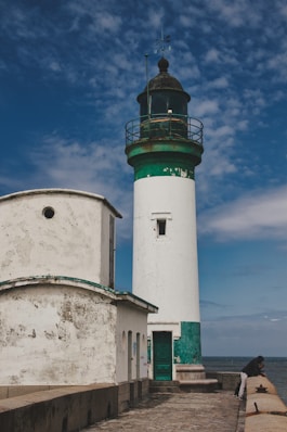 white and green concrete lighthouse under blue sky during daytime