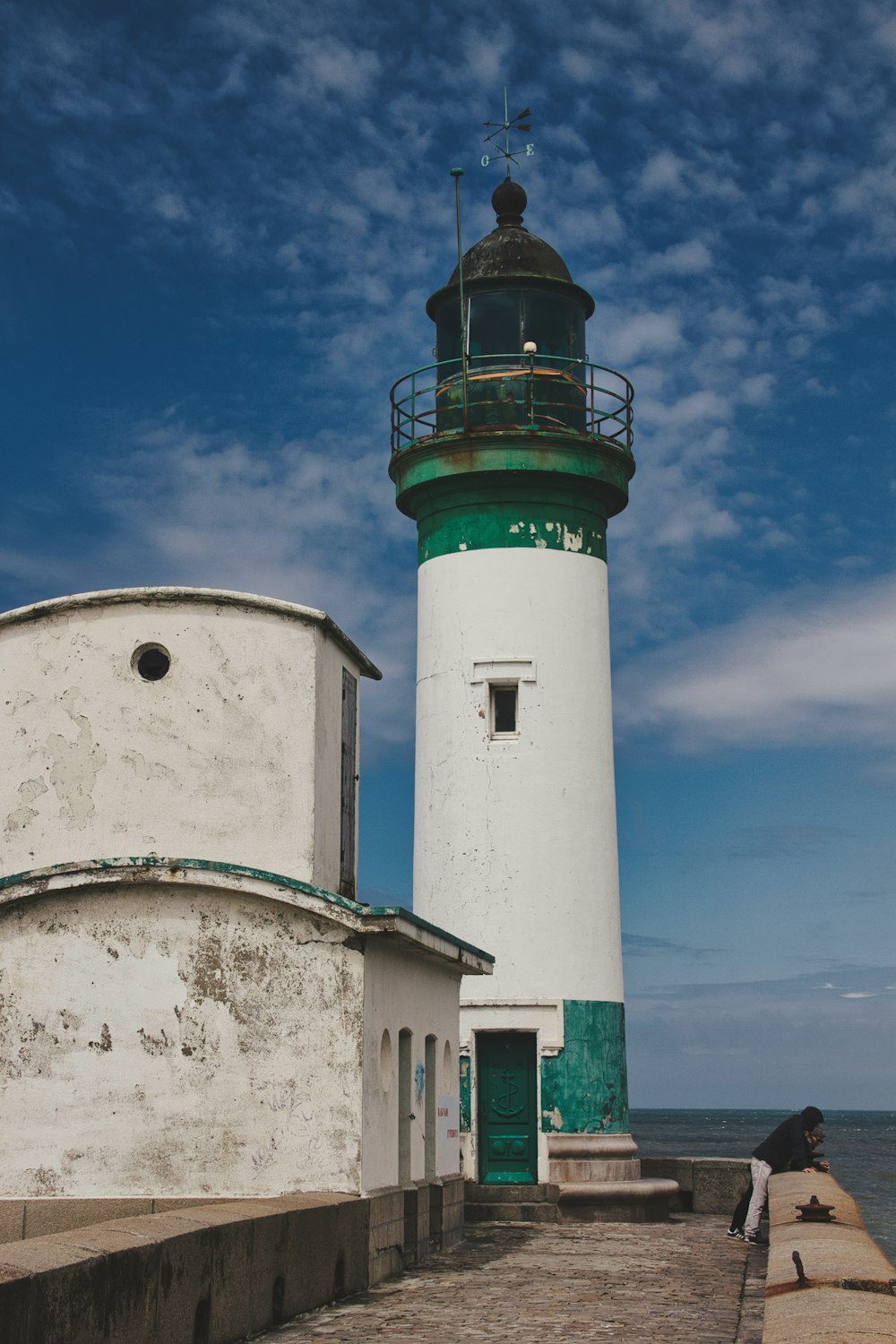 white and green concrete lighthouse under blue sky during daytime