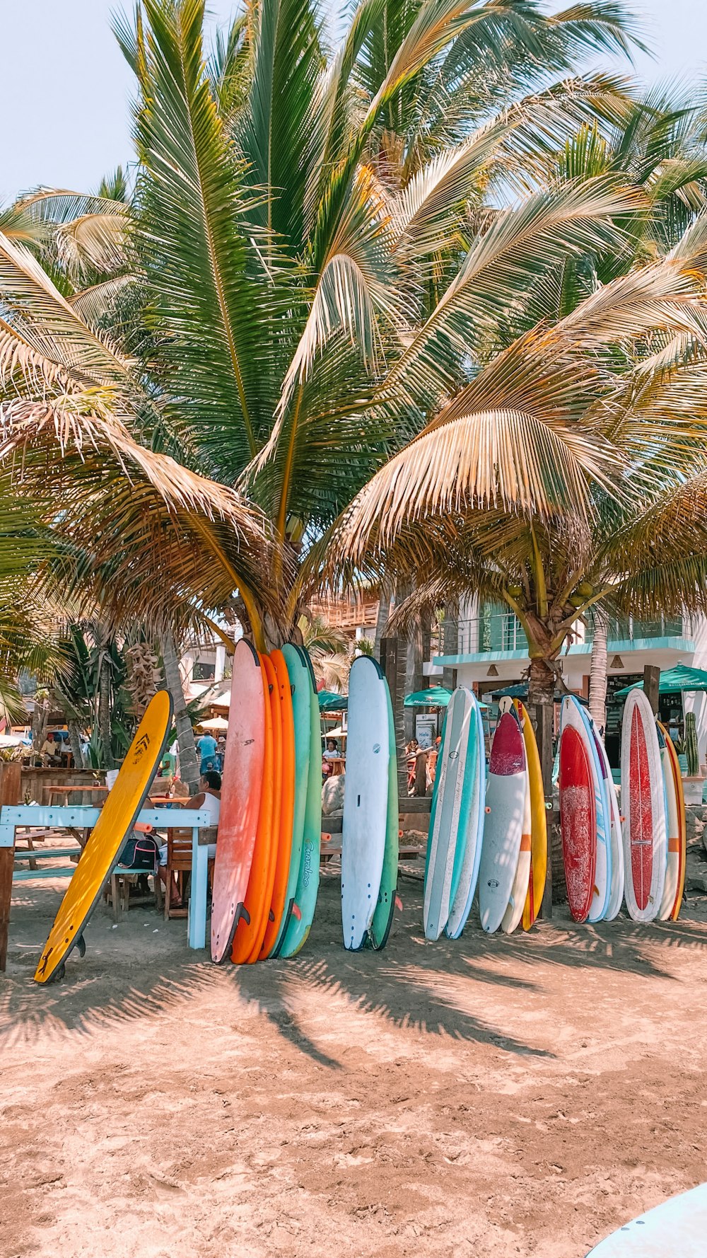 Tabla de surf blanca y azul en la playa durante el día