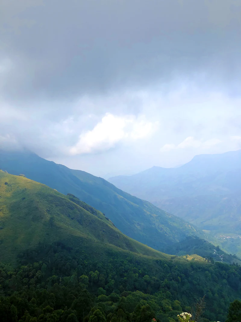 Blue mountain ridges receding under soft monsoon cloud