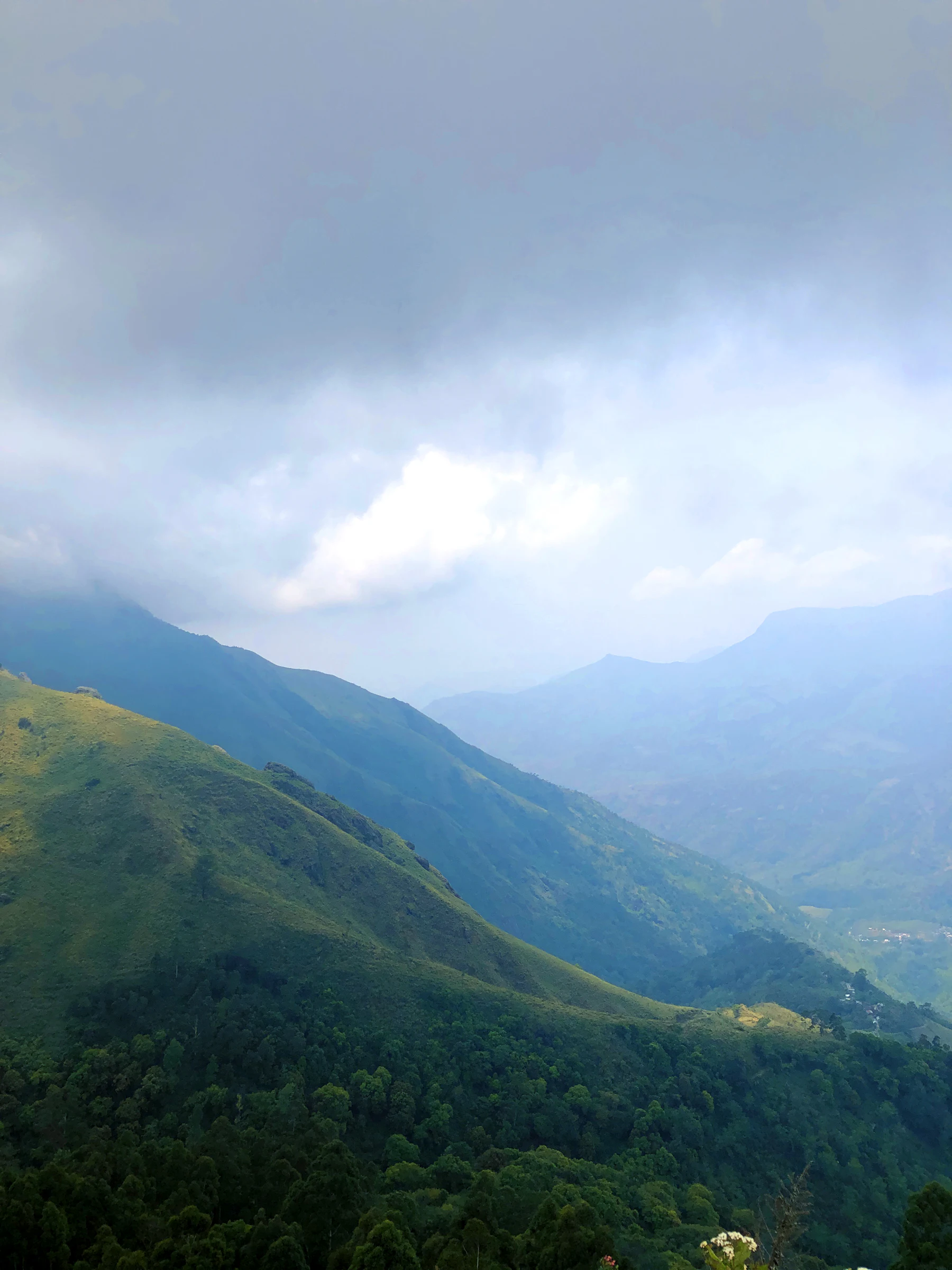 Blue mountain ridges receding under soft monsoon cloud