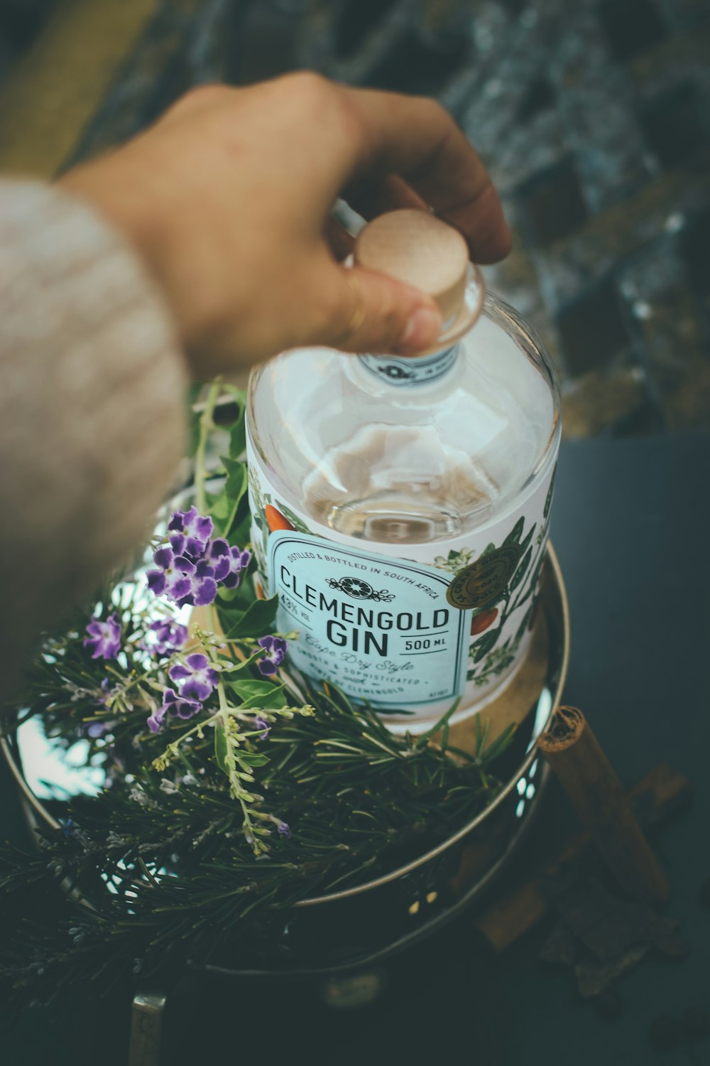 person holding clear glass bottle