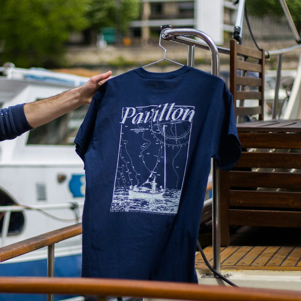 man in blue crew neck t-shirt holding blue plastic hanger