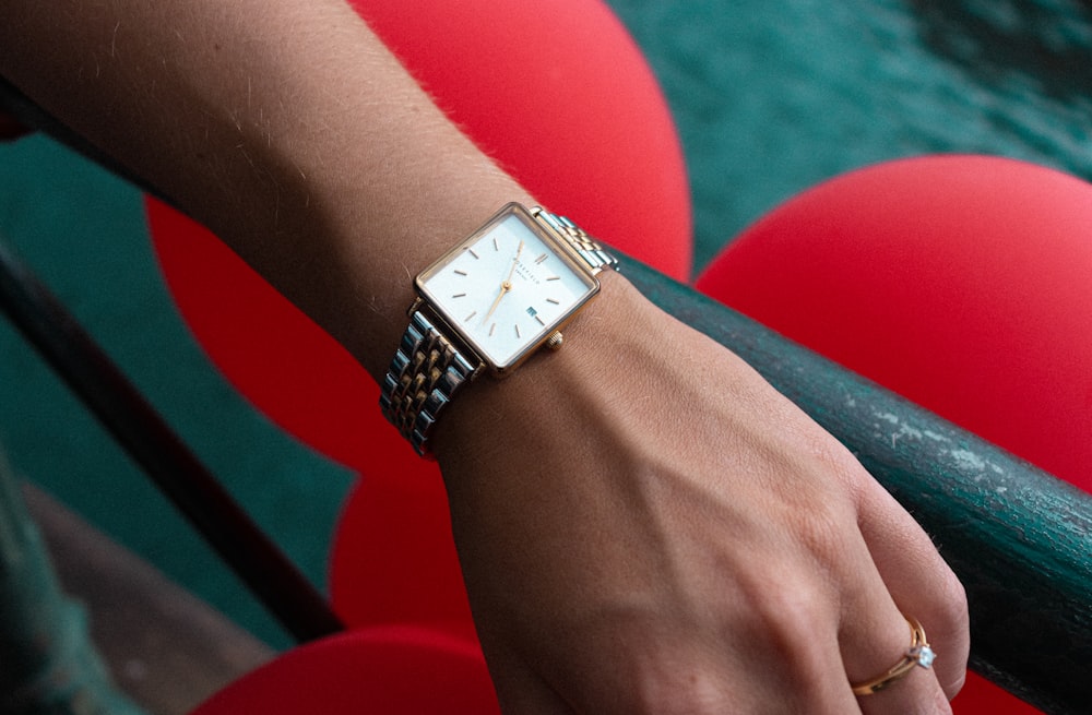 person wearing silver link bracelet analog watch