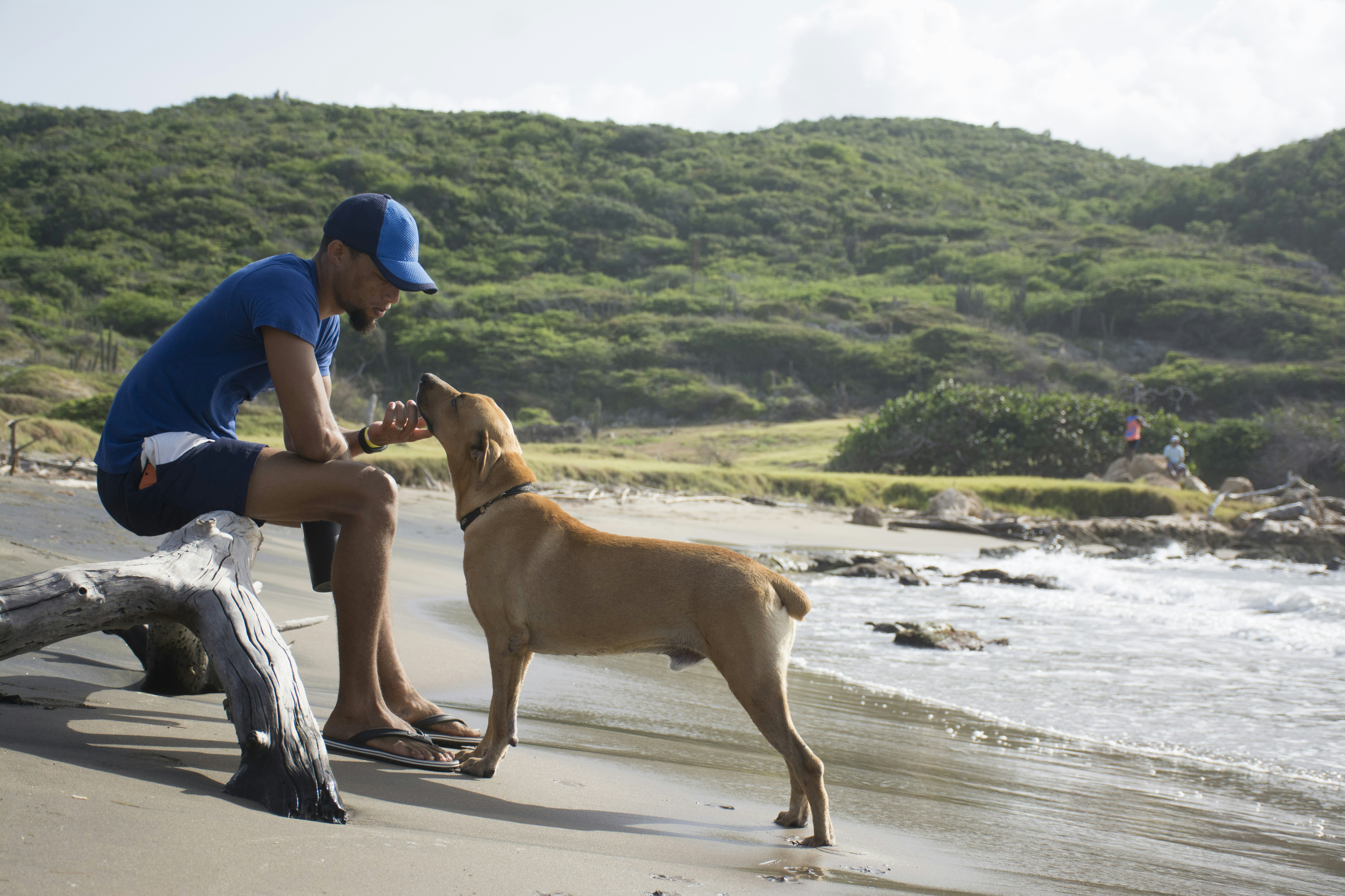 woman in blue tank top and white skirt sitting on white and black textile beside brown, A man and his best friend. Treasure Beach, Jamaica