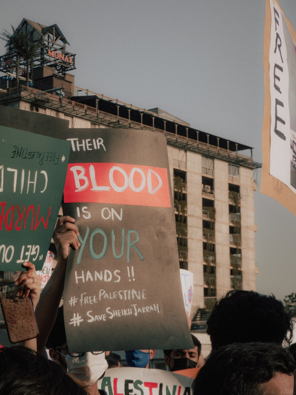 man in black jacket holding green and white signage