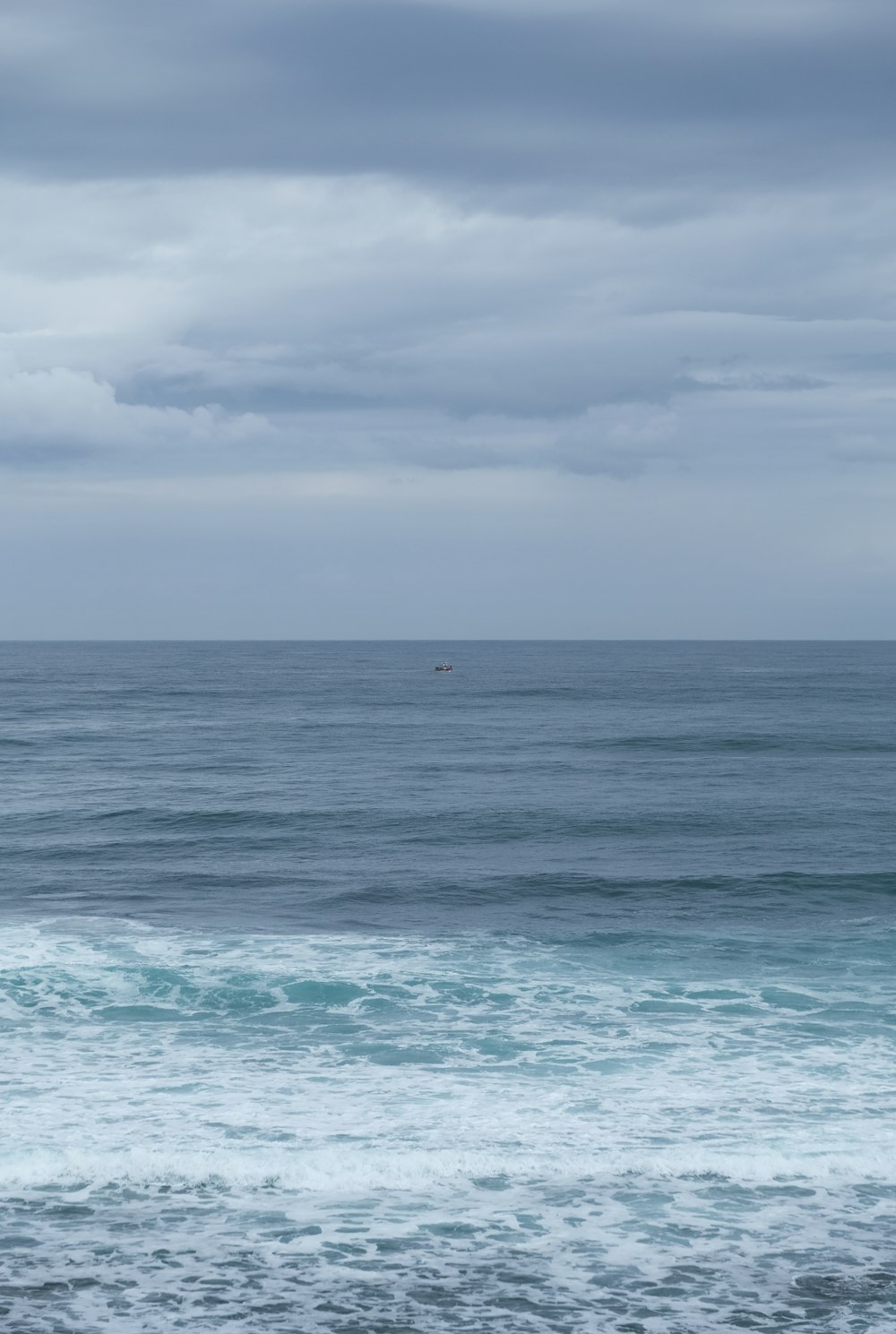 blue ocean water under white clouds during daytime