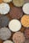 Circular bowls filled with various dried grains and legumes such as lentils, rice, beans, corn, sunflower seeds, chickpeas, and others are arranged on a flat surface. The bowls are placed closely together, creating a pattern of different colors and textures.