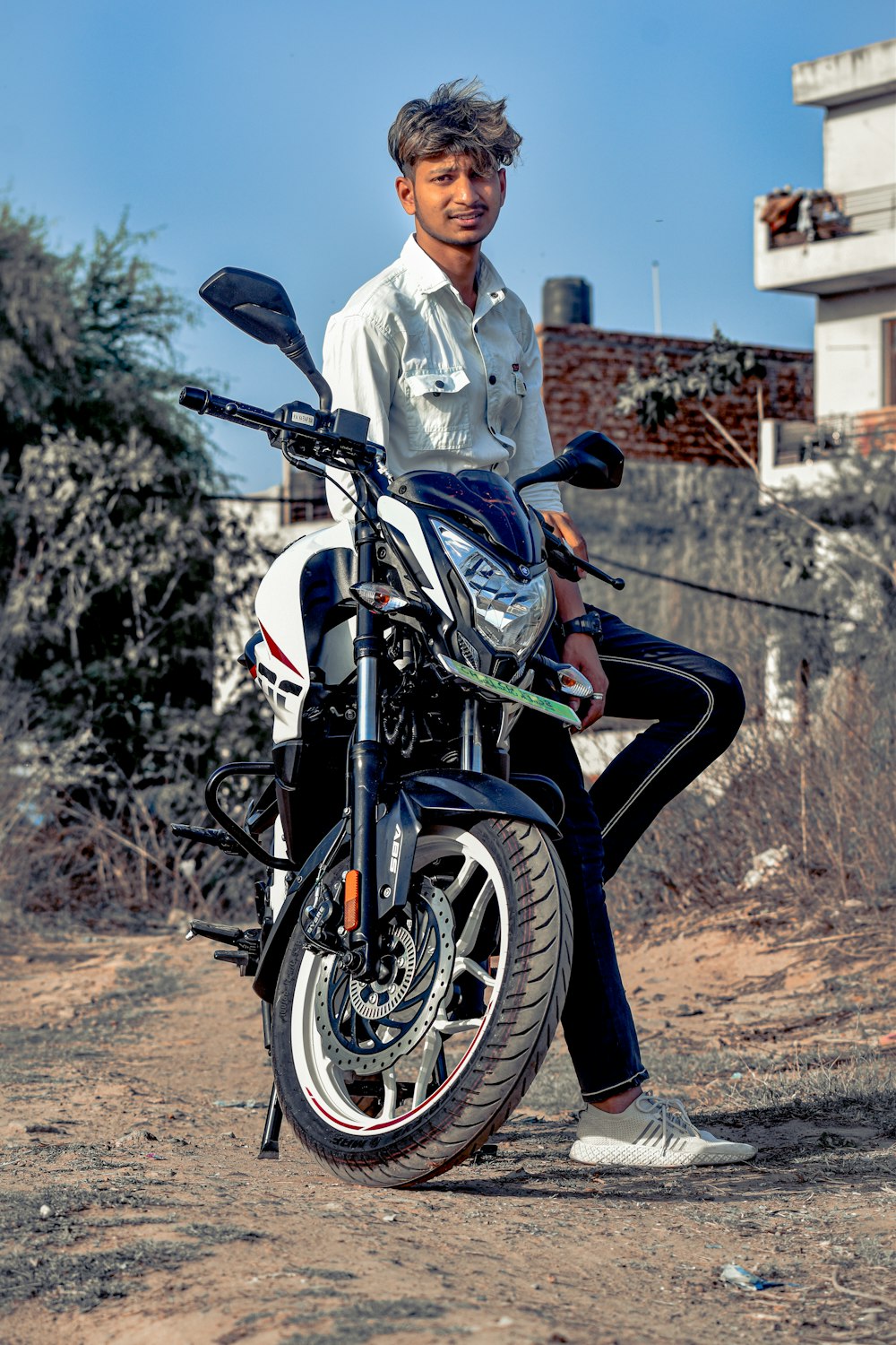 man in white dress shirt riding on black motorcycle during daytime