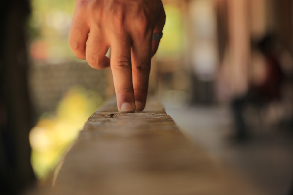 person holding brown wooden plank