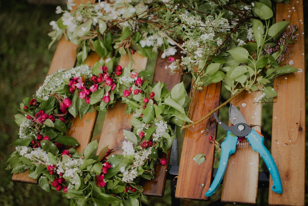 pink and white flowers on brown wooden fence