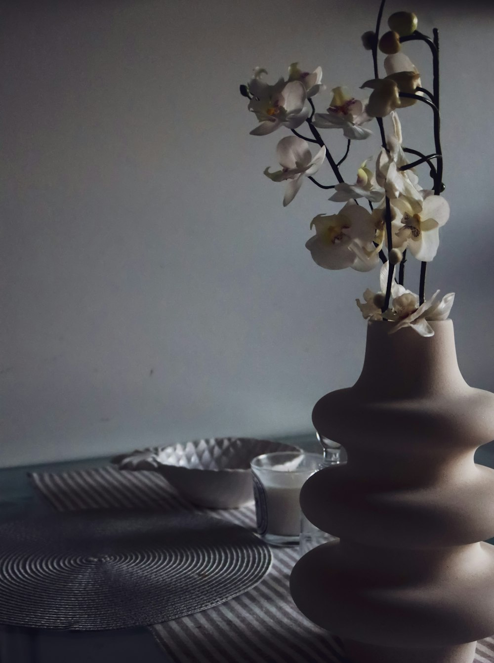 white roses in white ceramic vase on table