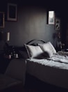 A cozy bed adorned with soft linens and pillows in a well-lit room.
