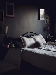 A cozy bedroom showcasing tasteful interior decoration with soft lighting and textured fabrics.